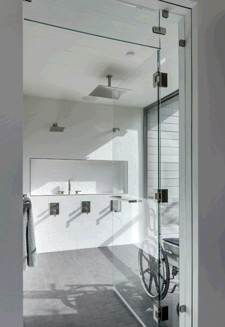 Modern bathroom with glass shower door and wheelchair access.