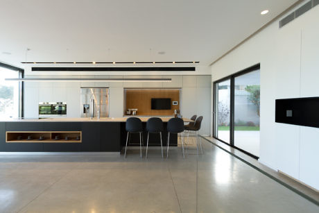 Modern kitchen interior with sleek counters and large windows.