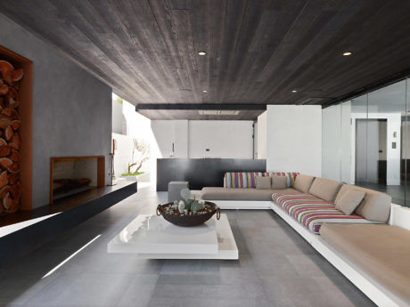Contemporary living space with sleek furnishings and dark wood ceiling.