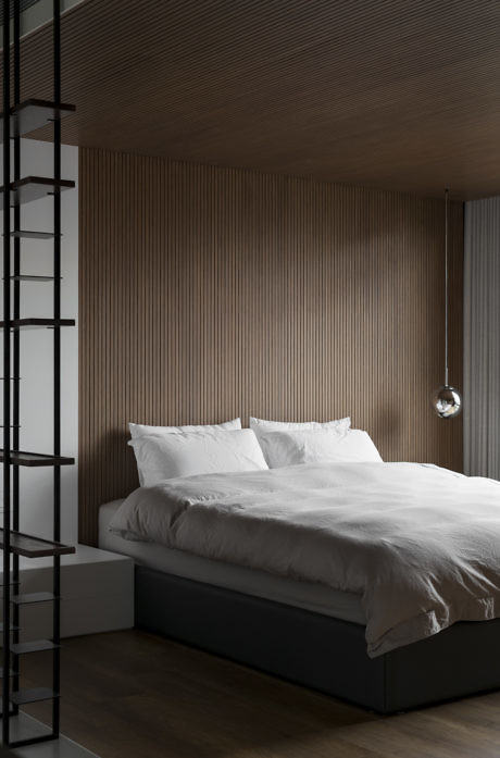 Minimalist bedroom with wooden slatted walls and a monochrome palette.