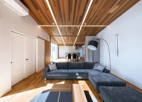Contemporary living space with wooden ceiling beams and a large gray sofa.
