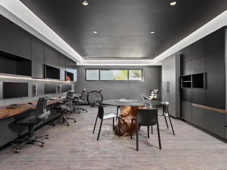 Contemporary office with sleek black furniture and a wooden table.