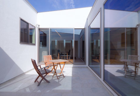 Contemporary courtyard with sliding glass doors and minimalist furniture.