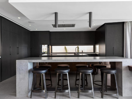 Sleek minimalist kitchen with dark cabinetry and island bar.