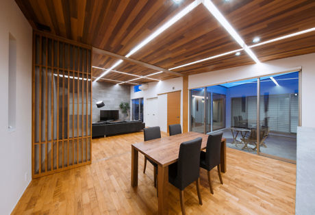 Contemporary interior with wooden beams, dining table, and ambient lighting.