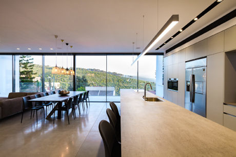 Sleek kitchen with panoramic windows overlooking hills