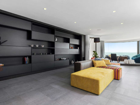 Sleek living room with gray tones, minimalist shelving, and a vibrant