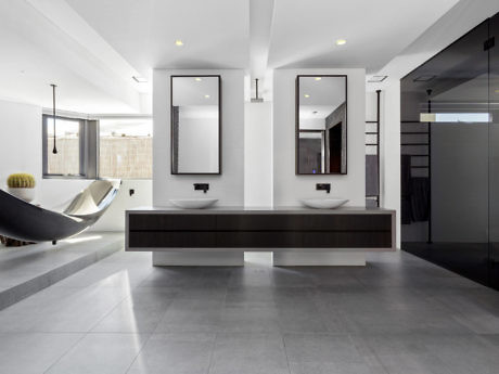Sleek bathroom interior with dual vanities and large mirrors.