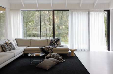 Contemporary living room with floor-to-ceiling windows and neutral tones.