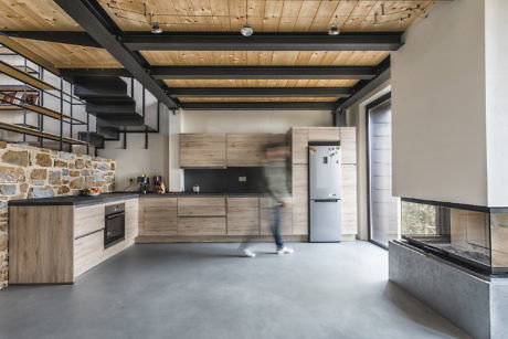 Contemporary kitchen with wood accents and stone wall.