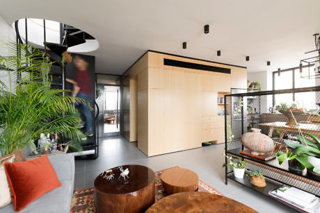 Modern living room with a spiral staircase and wood accents.