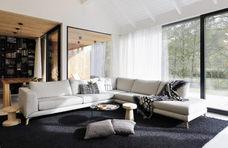 Contemporary living room with large windows and wooden accents.