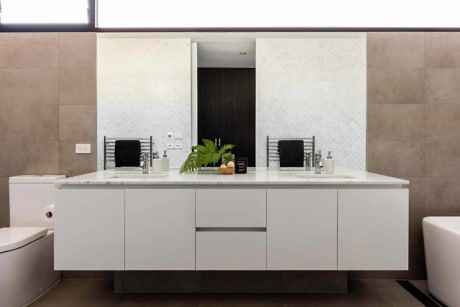 Modern bathroom vanity with dual sinks and a wall mirror.