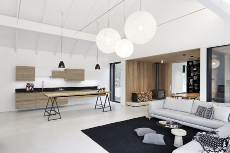 Modern living room with white walls, wooden accents, and designer lights.