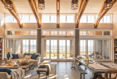 Bright and airy beachfront living room with large windows and wooden beams.