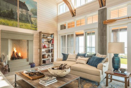 Cozy living room with fireplace, high ceilings, and large windows.