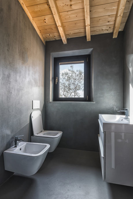 Modern bathroom with gray walls, wooden ceiling, and a small window.