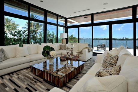 Chic living room with floor-to-ceiling windows and waterfront view.