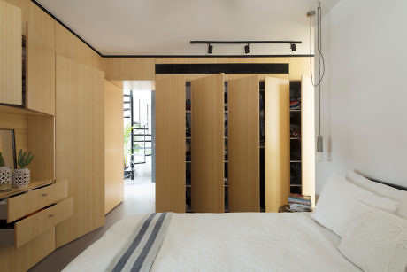 Minimalist bedroom with wooden sliding doors and built-in shelves.
