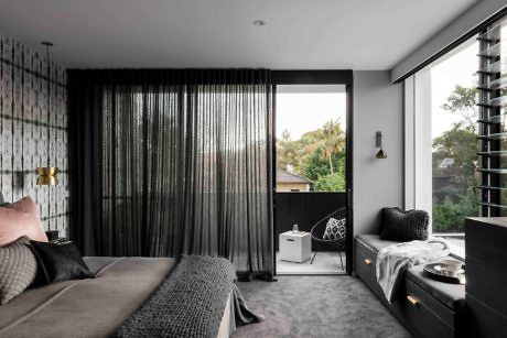 Contemporary bedroom with monochrome decor and floor-to-ceiling windows.