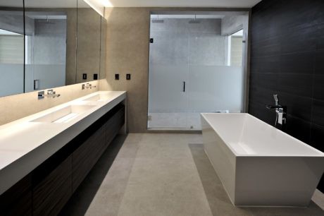 Sleek bathroom with dual sinks, freestanding tub, and glass shower