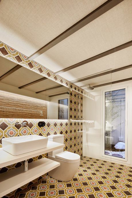 Contemporary bathroom with geometric tiles and sleek fixtures.