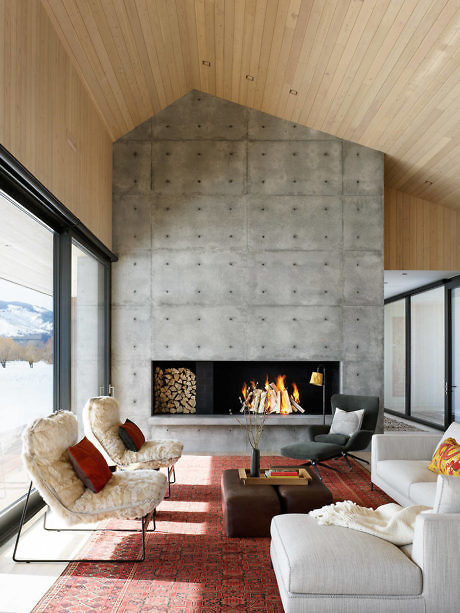 Contemporary living room with concrete fireplace and wood ceiling.