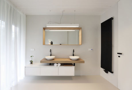 A modern bathroom with dual sinks, a large mirror, and minimalist decor.