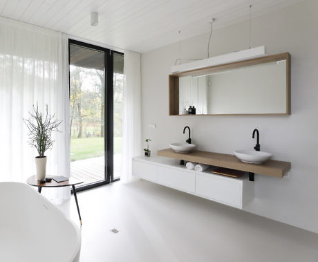 Minimalist bathroom with double sink and freestanding bathtub.