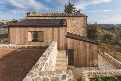 Contemporary-rustic hybrid building with timber cladding, rising amidst rolling countryside