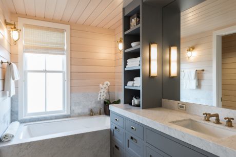 Contemporary bathroom with a white bathtub, wooden accents, and elegant lighting.