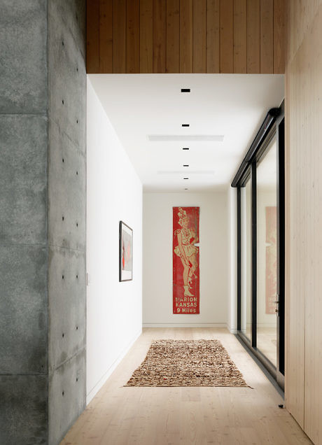 Minimalist hallway with concrete, wood, and art accents.
