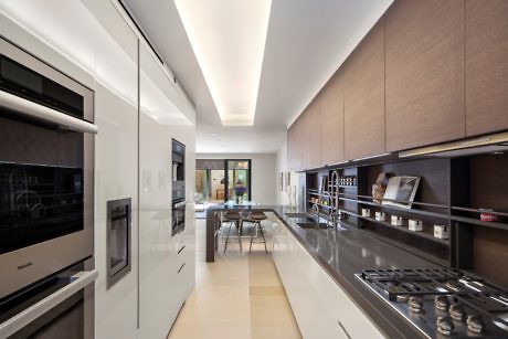 Contemporary kitchen with sleek appliances and wooden cabinets.