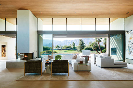 Spacious living room with large windows and mountain view.