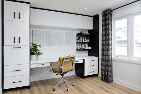 Contemporary home office with white desk, black accents, and tan chair.
