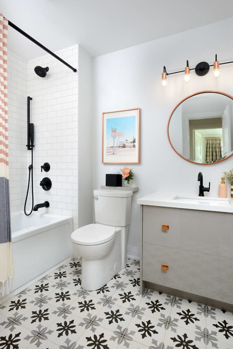 Modern bathroom with patterned floor, white subway tiles, and black fixtures.