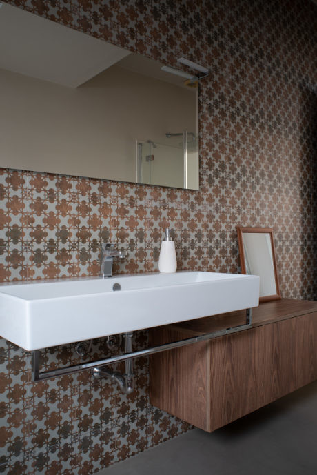 Modern bathroom with patterned wallpaper and floating sink vanity.