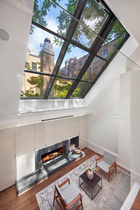Contemporary living space with a fireplace and a striking glass ceiling.