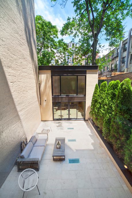 Urban courtyard with minimalist design and green hedge.