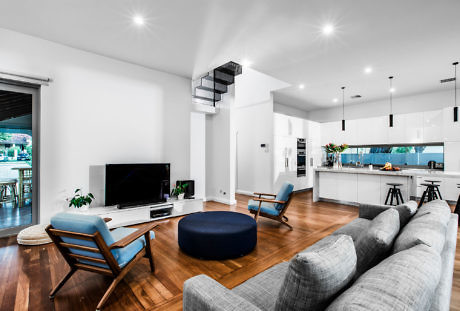 Contemporary living space with open kitchen and sleek furnishings.