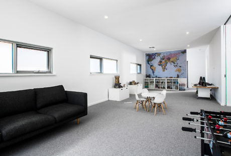 Minimalist interior with world map decor, a foosball table, and sleek