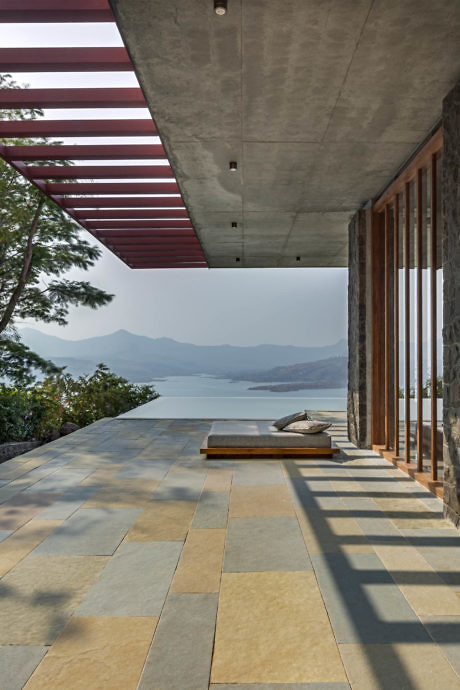 Contemporary terrace with tiled floor, glass walls, lake view.