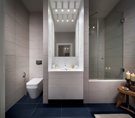 Contemporary bathroom with sleek vanity, glass shower, and tiled walls.