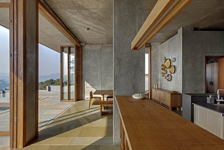 Contemporary interior with concrete walls and wooden accents; expansive view.