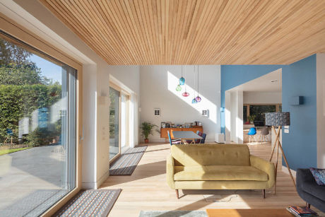 Bright, airy living space with wooden ceiling and colorful hanging lights.