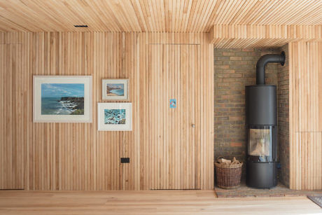 Wood-paneled room with a fireplace and framed artwork on the wall.