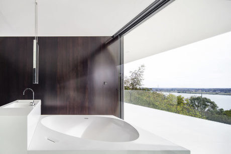 Modern bathroom with large window overlooking a scenic view.