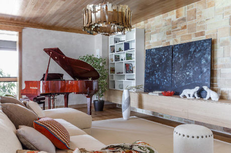 Contemporary living space with red grand piano and stone wall accents.