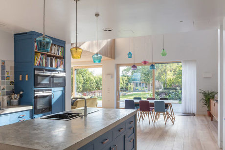 Contemporary kitchen with blue cabinetry and colorful pendant lights.
