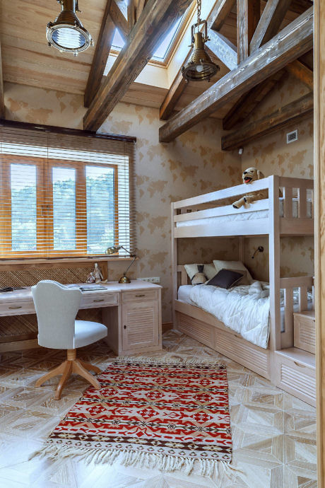 Cozy attic bedroom with bunk beds, study area, and rustic wooden beams.